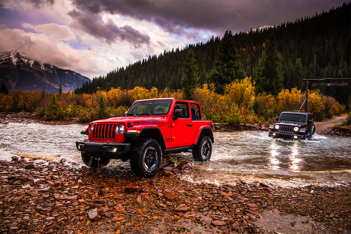 Jeep Wrangler 2019 dans une rivière peu profonde, illustré en rouge et gris