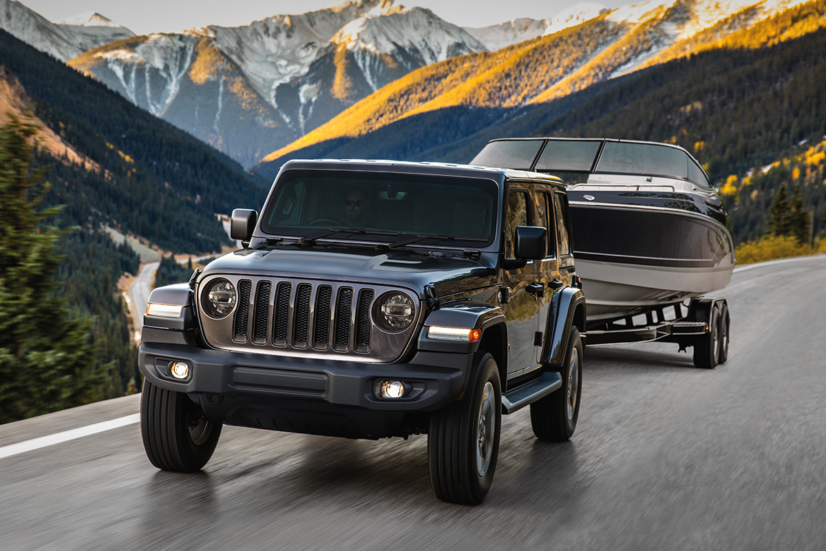 2019 Jeep Wrangler driving over sand dune, shown in silver