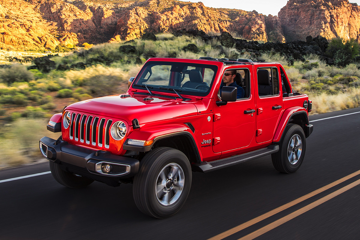 Jeep Wrangler 2020 rouge roulant sur une autoroute s’étendant sur un plateau.