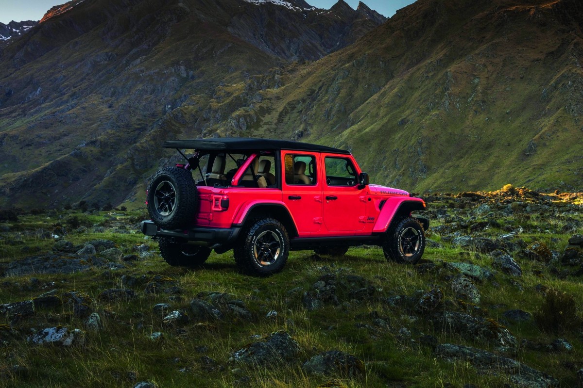 Le Jeep Wrangler 2020 rouge garé dans la nature, devant des montagnes