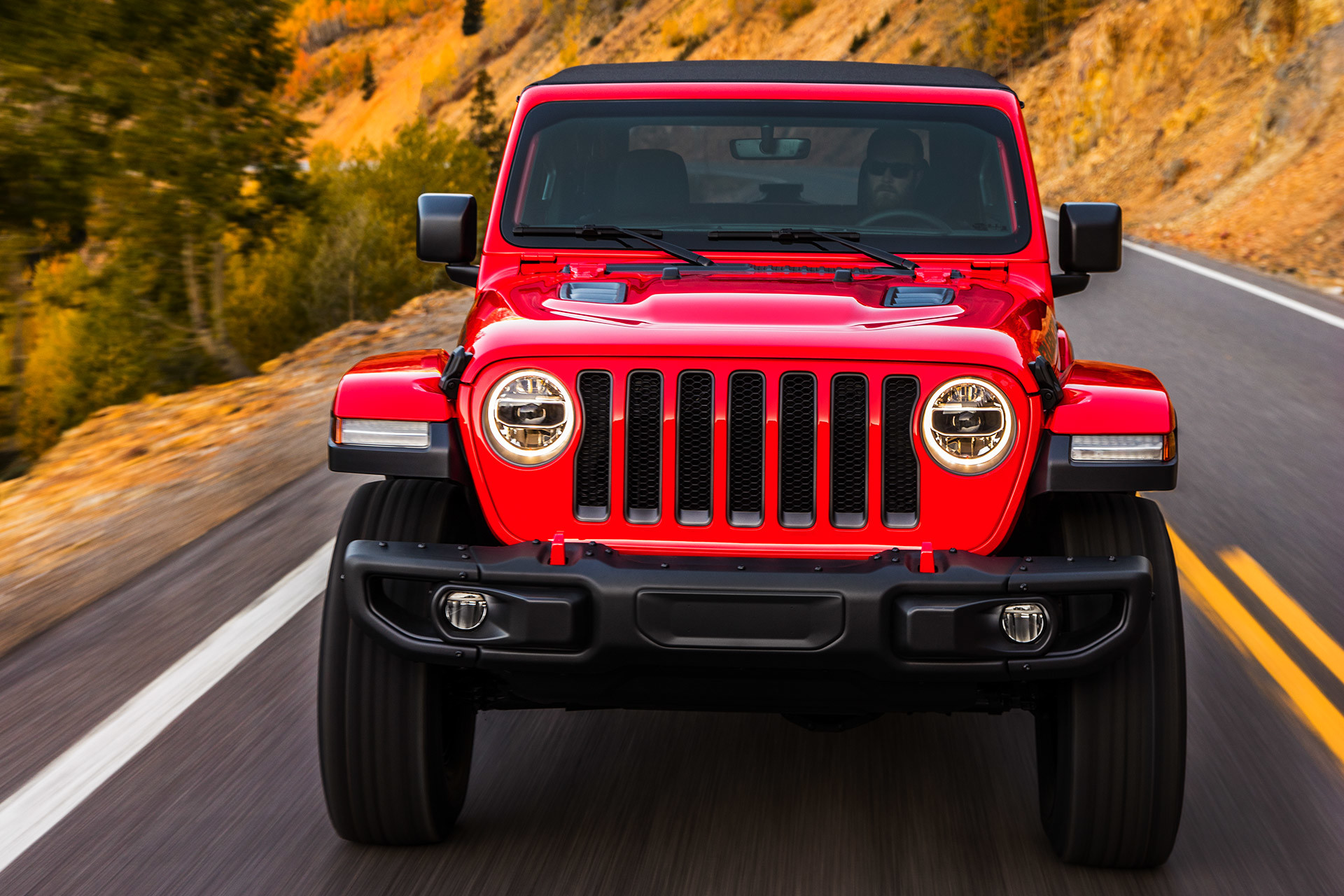 Front view of the 2020 Jeep Wrangler being driven on a country road through plains