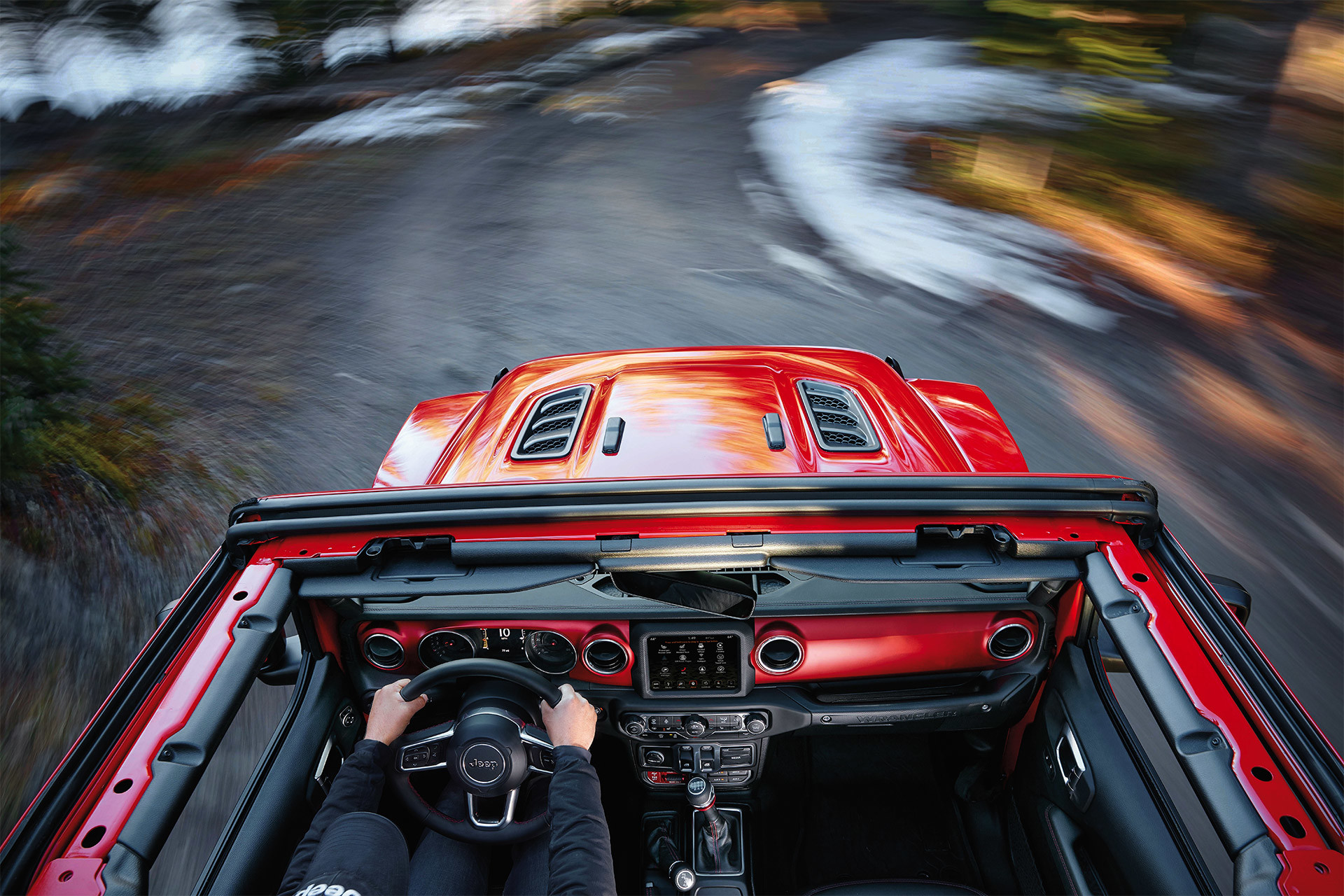 Birds eye view of the red 2020 Jeep Wrangler being driven on a dirt road
