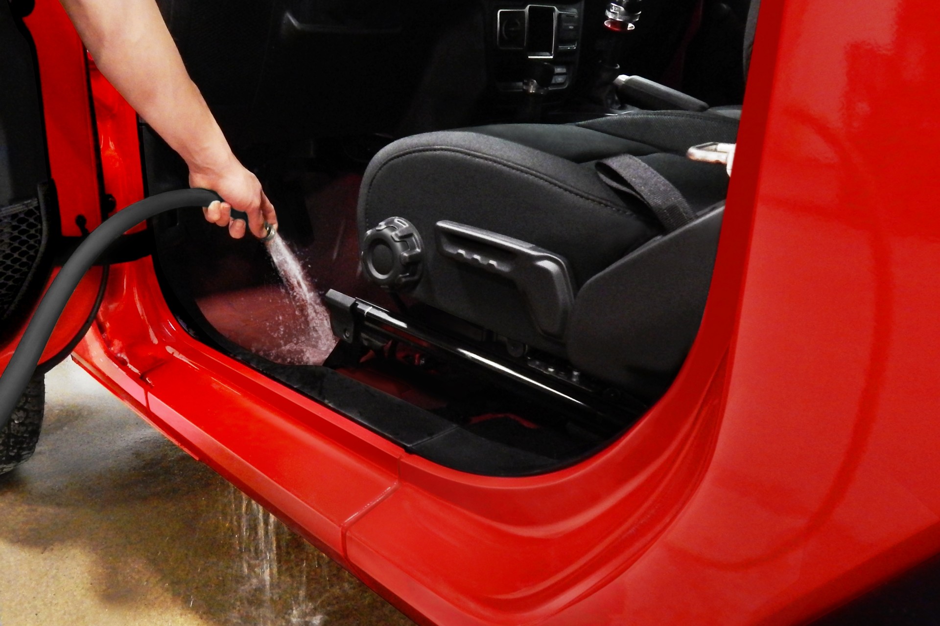 Personne lavant le plancher du Jeep Wrangler 2020 à l’eau