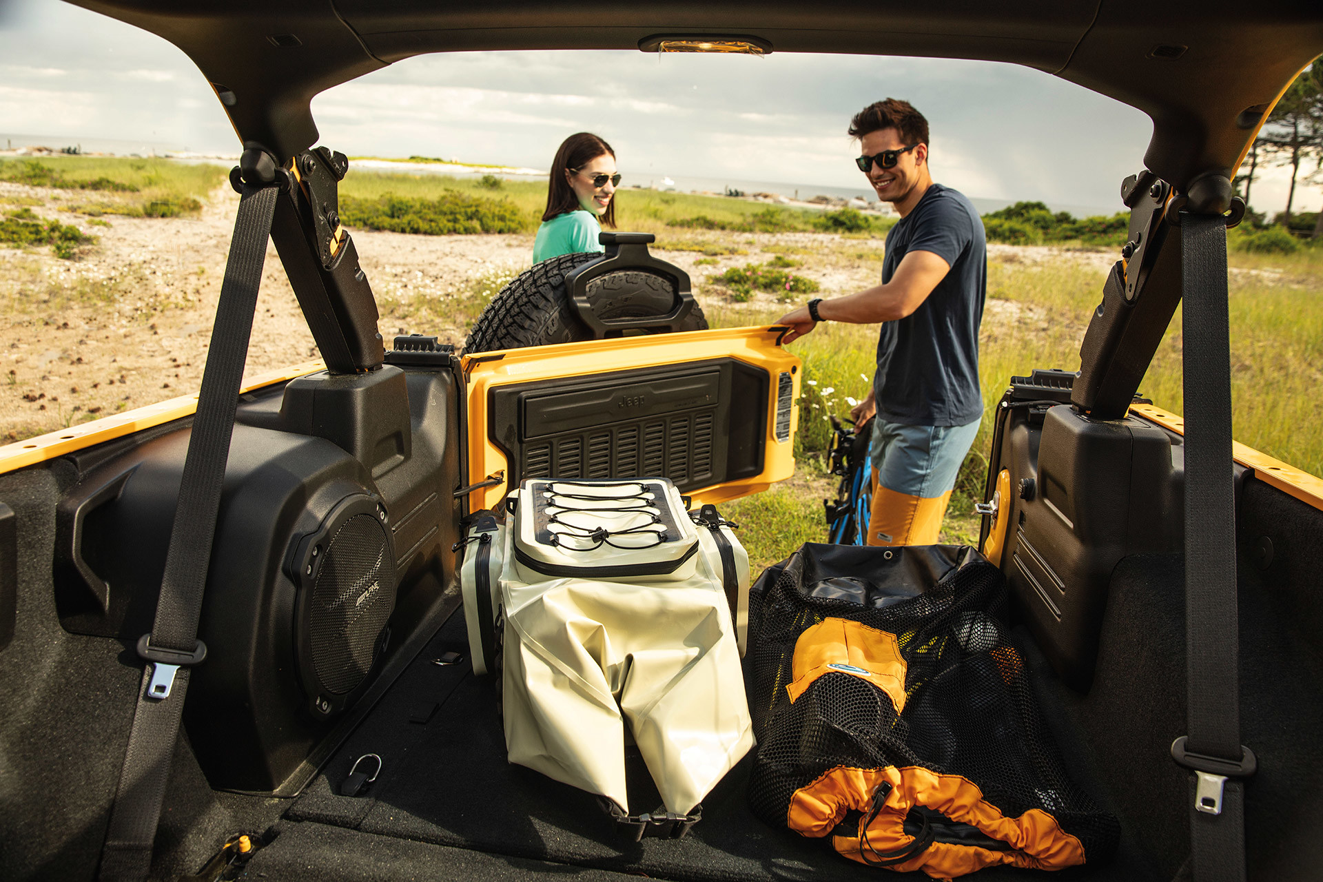 Couple unloading gear from the back of a 2021 Wrangler.