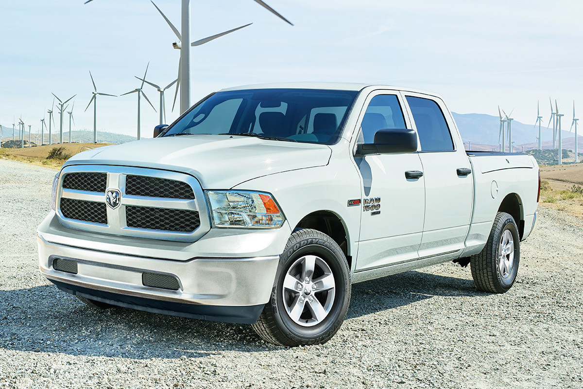 Ram 1500 DS 2019 blanc garé sur une route de gravier devant un champ parsemé d’éoliennes blanches.