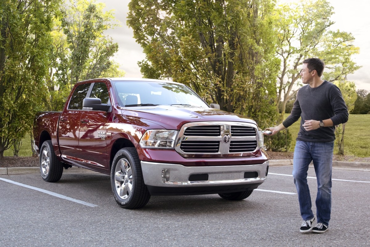 Le Ram 1500 Classic 2020 rouge immobilisé dans un stationnement pendant qu’un homme passe devant