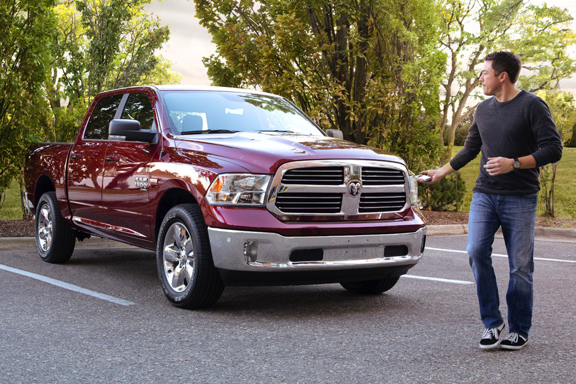 Vue d’un homme verrouillant un Ram 1500 Classic 2021 à couche nacré rouge avec le système d’entrée passive livrable en option
