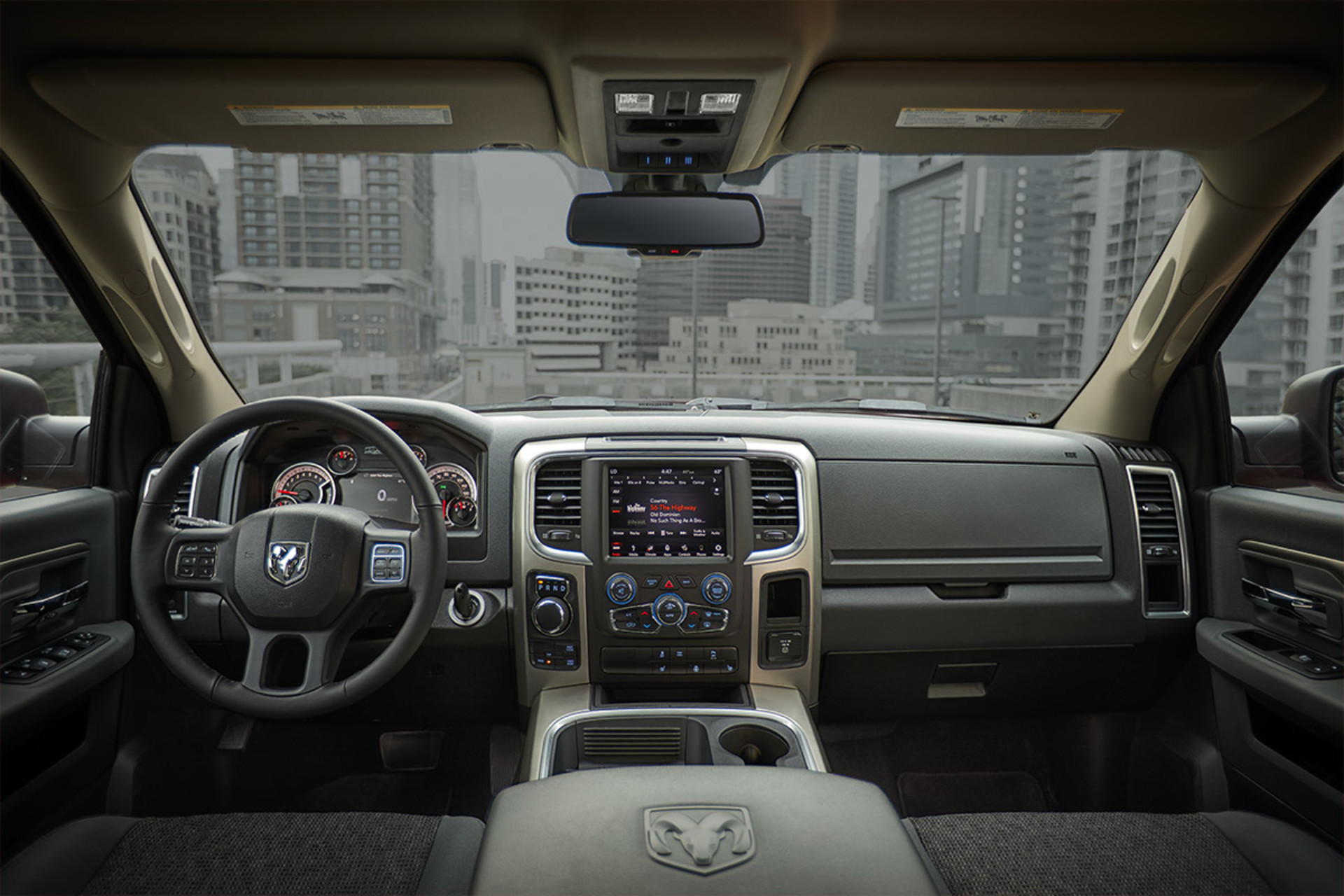 Gros plan du volant et du centre multimédia Uconnect avec un écran tactile de 8,4 po livrable en option à l’intérieur du Ram 1500 Classic 2021.