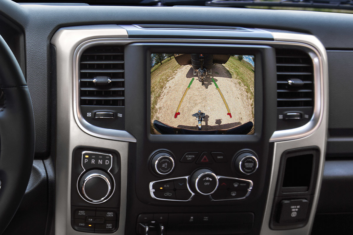 A close-up of a Uconnect multimedia system touchscreen displaying the dynamic gridlines that help drivers of the 2021 Ram 1500 Classic reverse using the ParkView Rear Back Up Camera.