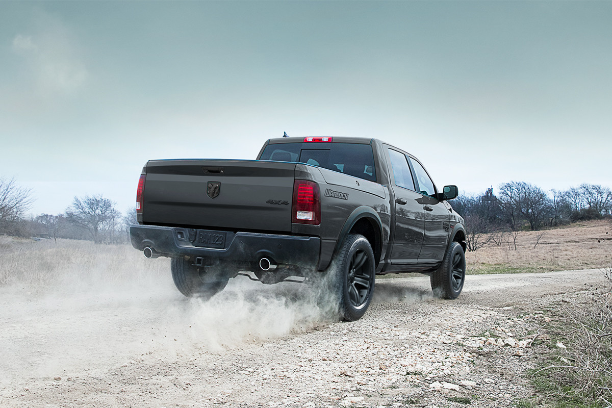 A black 2022 Ram 1500 Classic being driven on a gravel road.