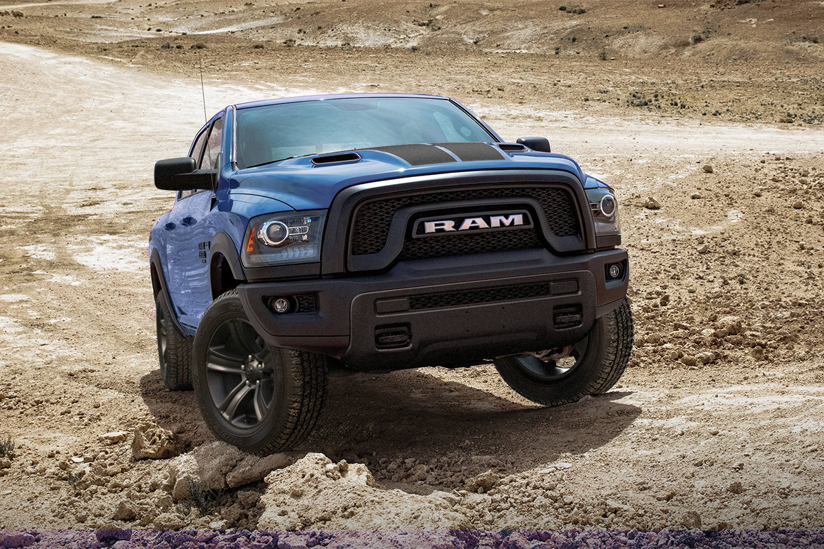 Vue avant d’un Ram 1500 Classic 2023 bleu stationné en montée sur un terrain désertique.