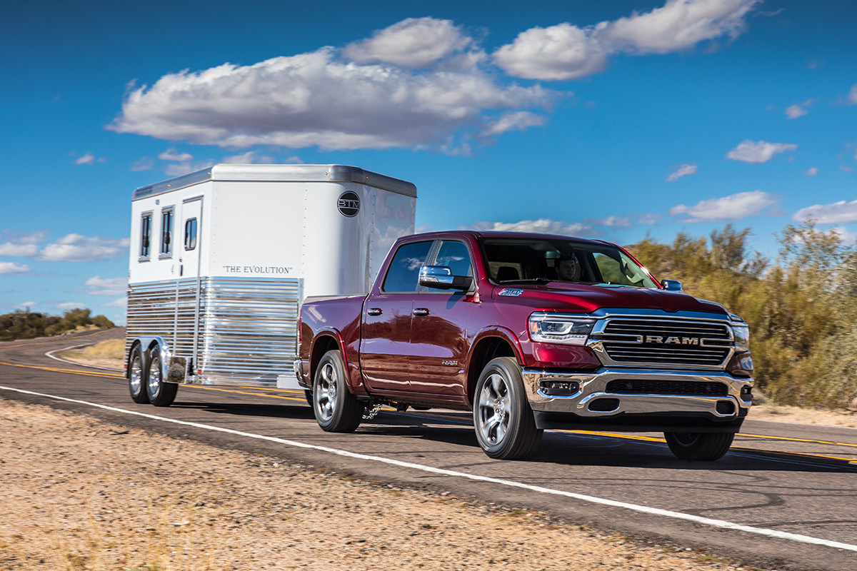 Red Ram 1500 DS Driving Through an Open Road Carrying a White Trailer