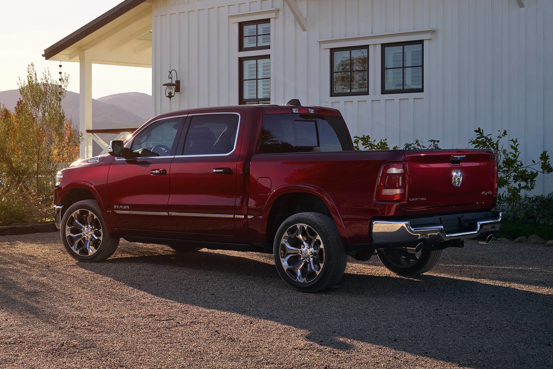 2019 Ram 1500 red sideview next to white house