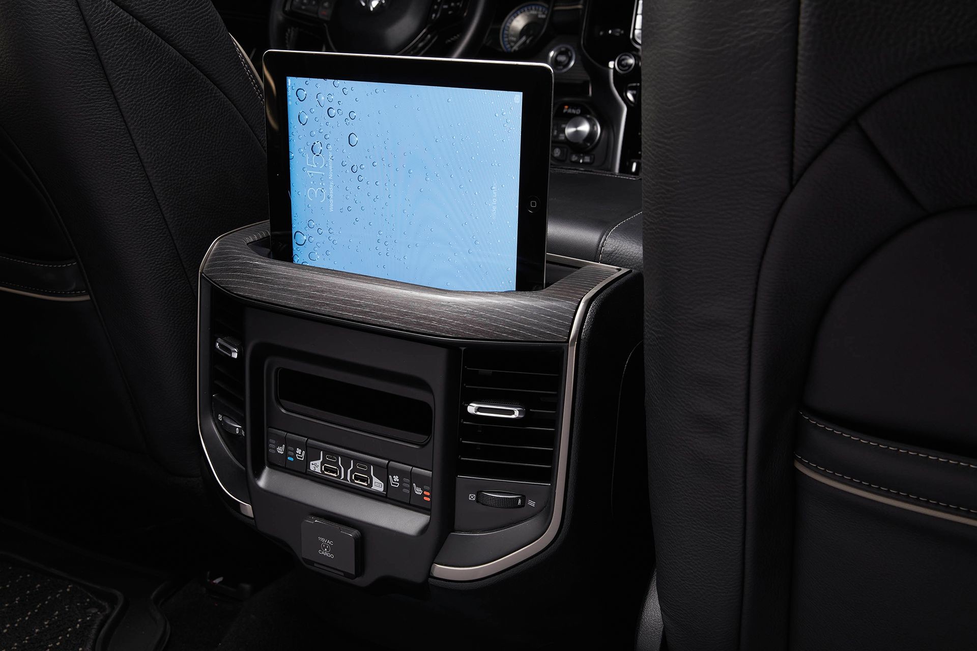 The rear seat control centre of the 2019 Ram 1500 with a tablet in the holder