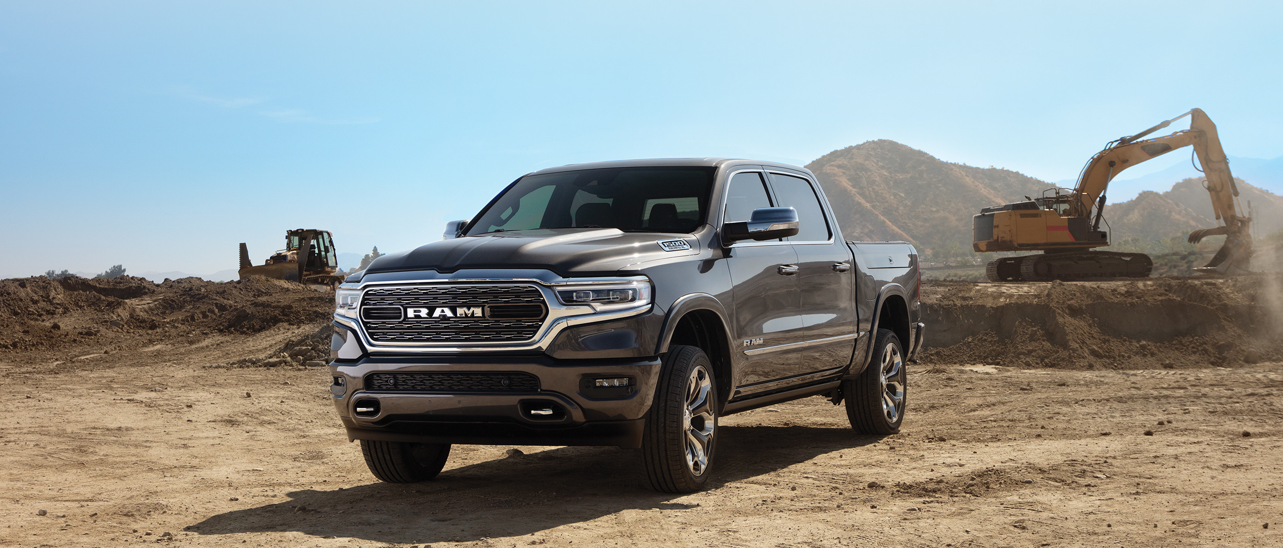Black 2019 Ram 1500, parked on the dirt in a construction zone.