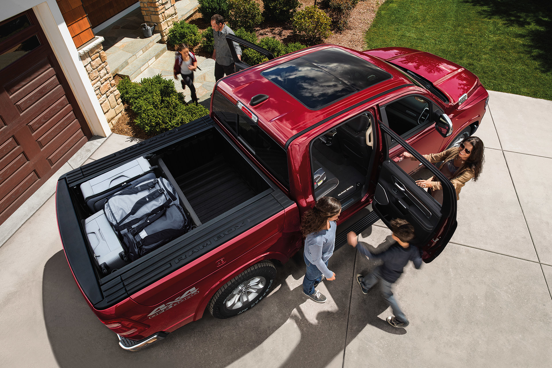 Une famille entrant dans un Ram 1500 2020 rouge vue aérienne
