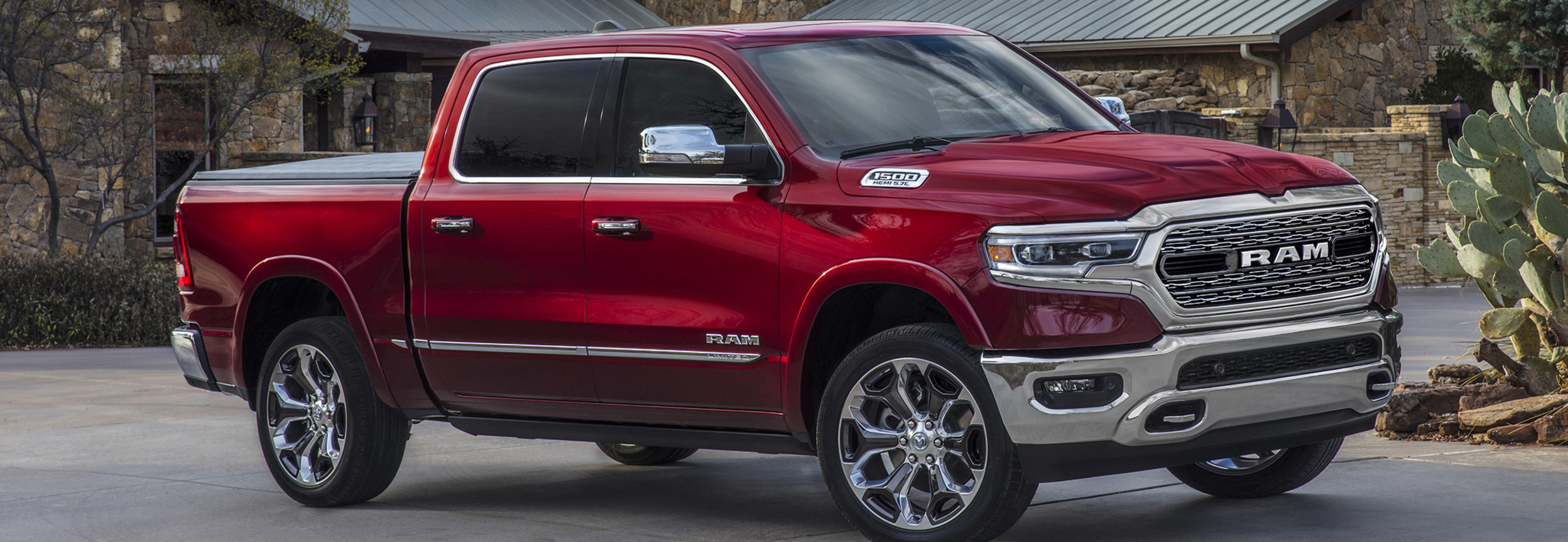Side view of a parked Red 2022 Ram 1500 in front of a house
