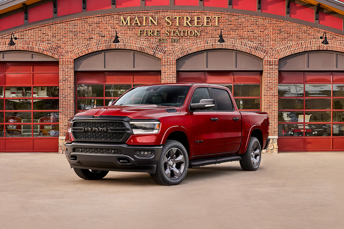 Un Ram 1500 Big Horn 2022 édition Built to Serve en couche nacrée ligne rouge stationné devant une caserne de pompiers.