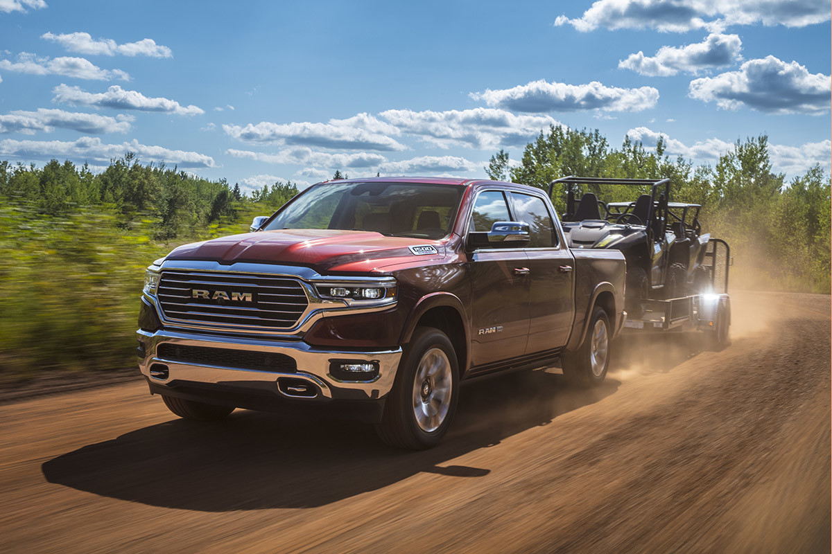 Red 2022 Ram 1500 DT towing two 4 wheelers
