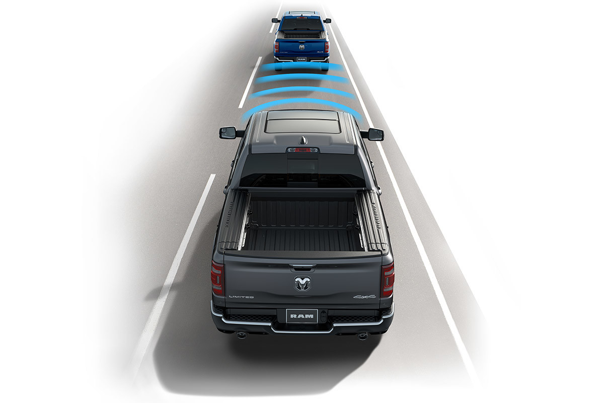 2022 Ram 1500 driving on a highway. Front sensors are visually represented by four curved lines.
