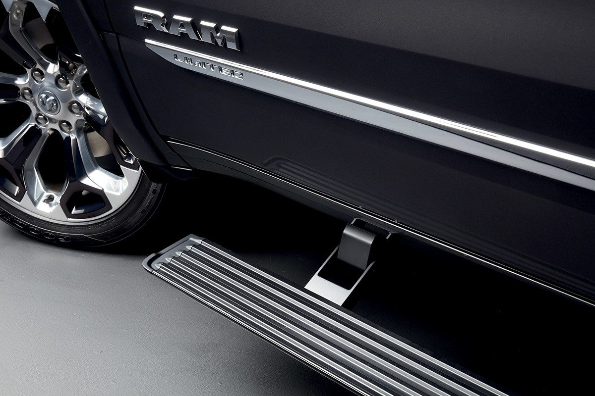 Close up of automatic power side steps mounted on a black Ram 1500 Limited