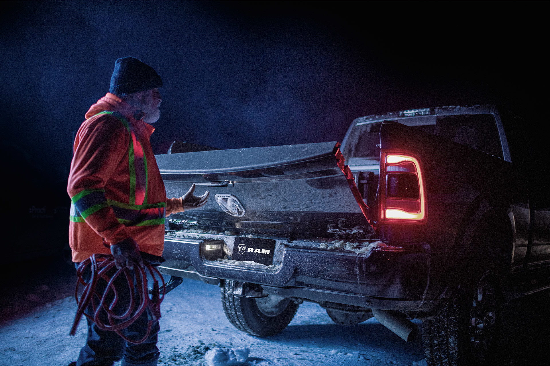 Homme ouvrant un Ram 1500 2022 couvert de givre, la nuit.