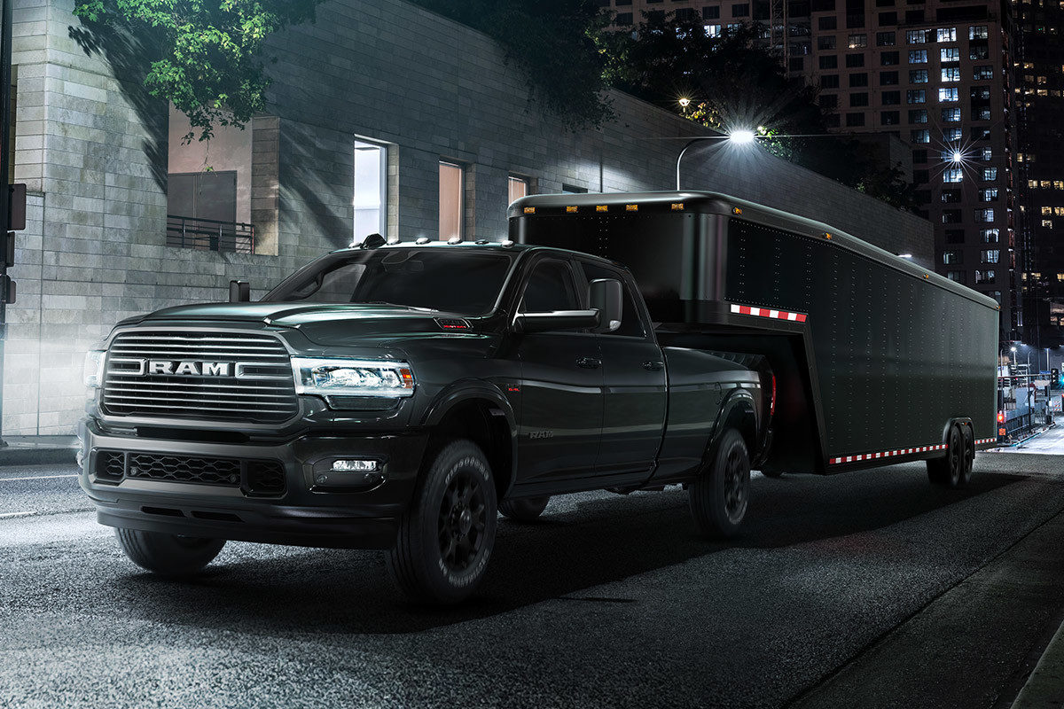 Le Ram 2500 2020 remorquant une caravane en traversant une ville la nuit
