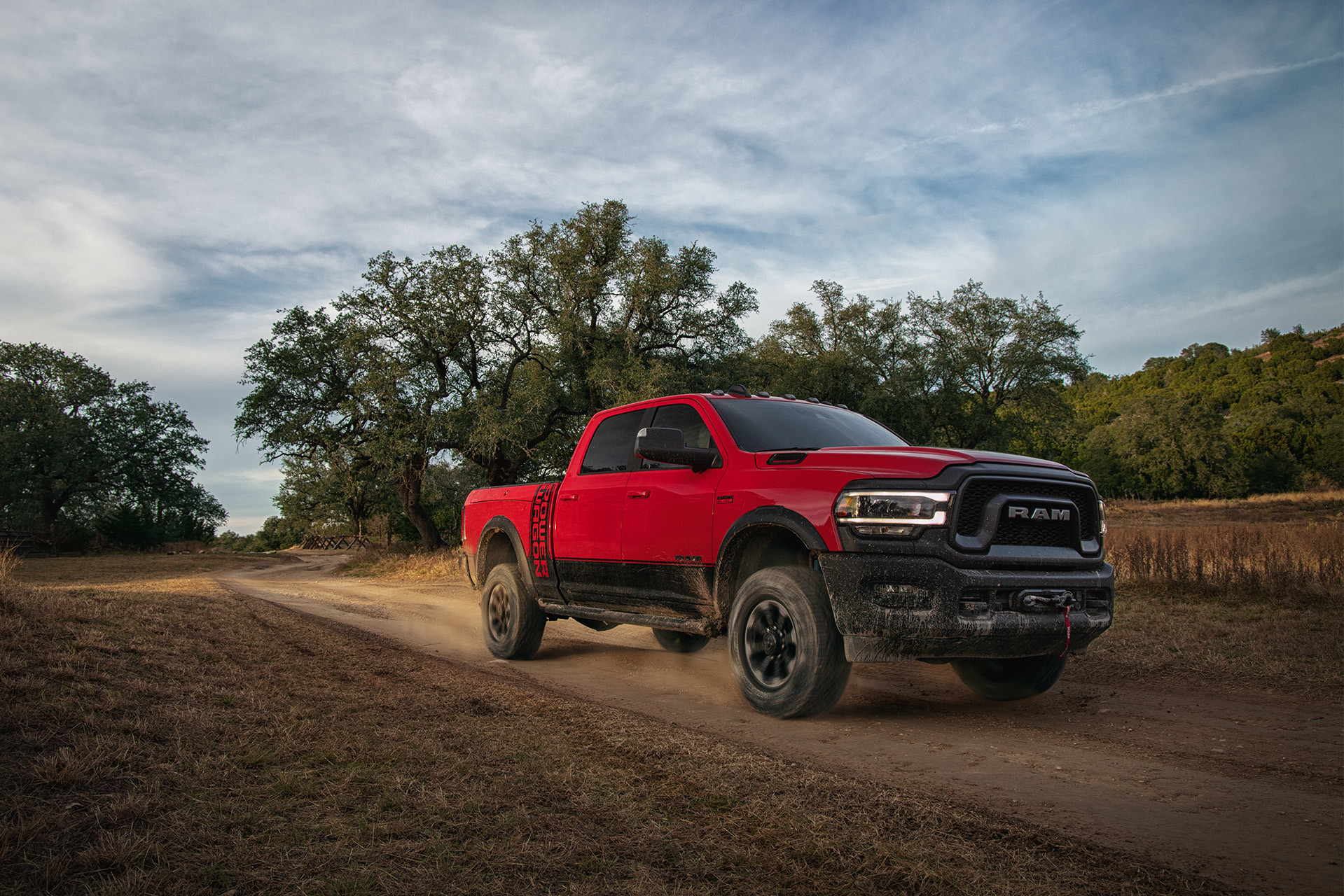 The 2020 Ram 2500 being driven on a dirt road through plains