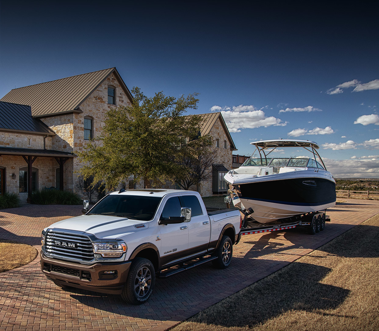 The 2020 Ram 2500 parked on a driveway while towing a boat
