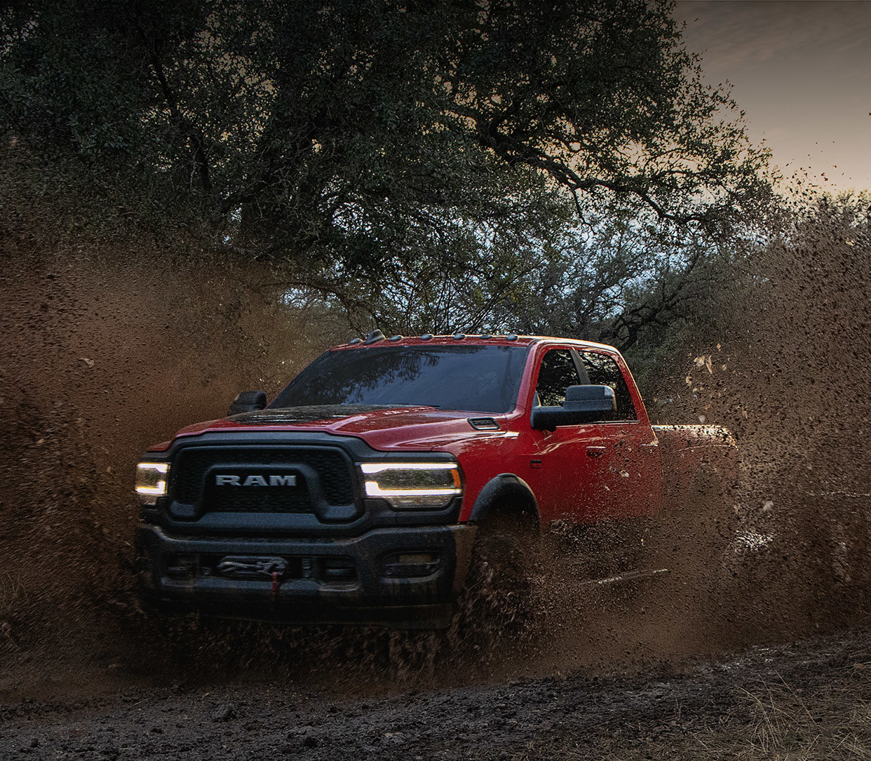 The 2020 Ram 2500 passing the muddy road through trees