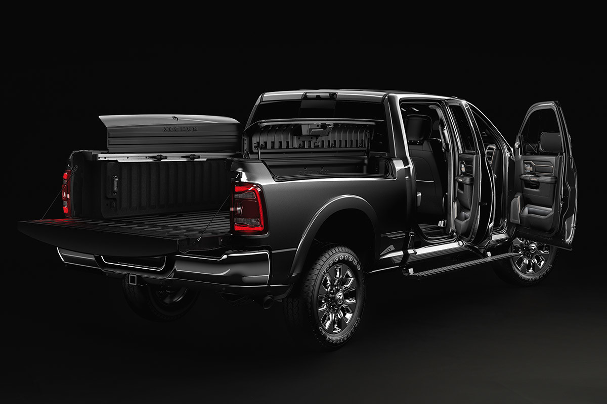 Vue arrière d’un Ram 2500 noir avec le système de rangement de caisse RamBox et les portes ouvertes.