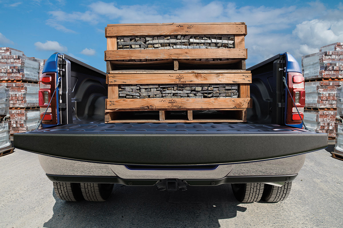Vue arrière d’un Ram 2500 2022, avec le hayon baissé qui laisse apparaître des caisses en bois sur la caisse du camion.