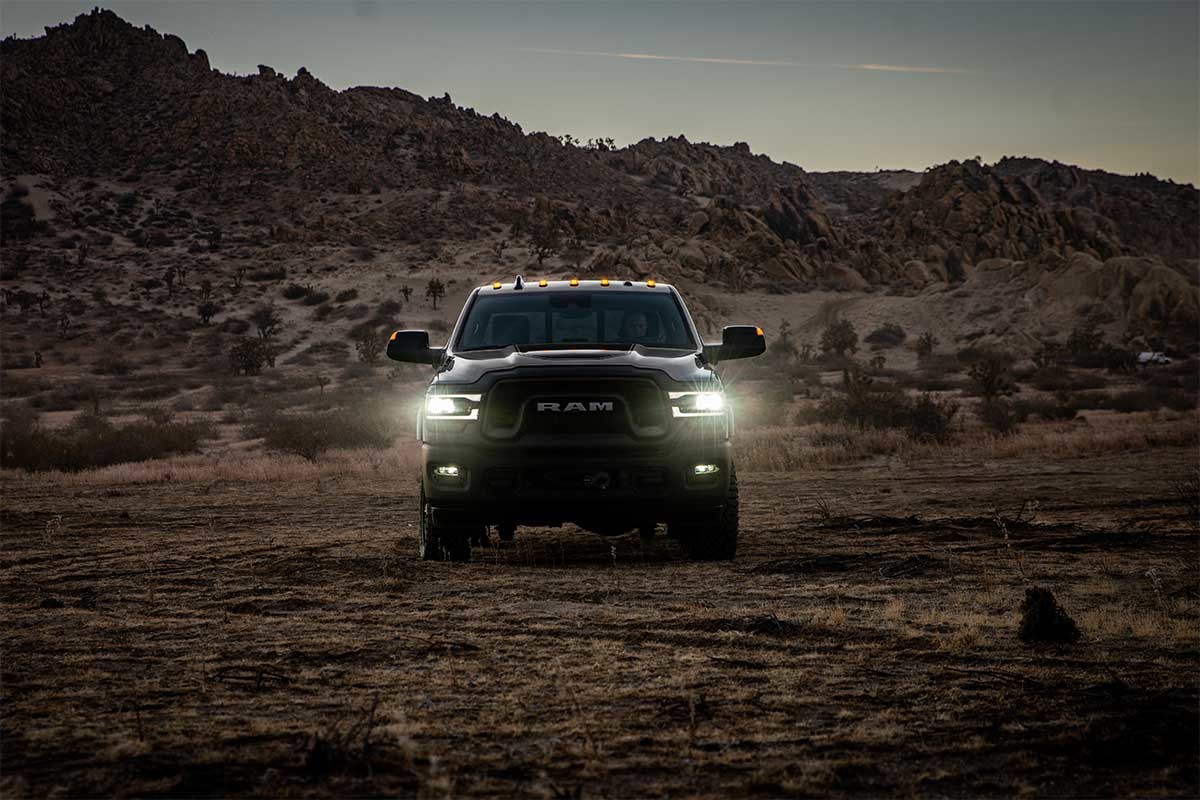 Front view of a 2022 Ram 2500, with its LED projector headlamps turned on.