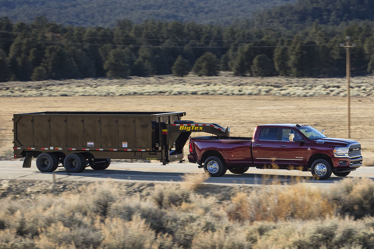 Dark red 2020 Ram 3500 hauling a dark green trailer.
