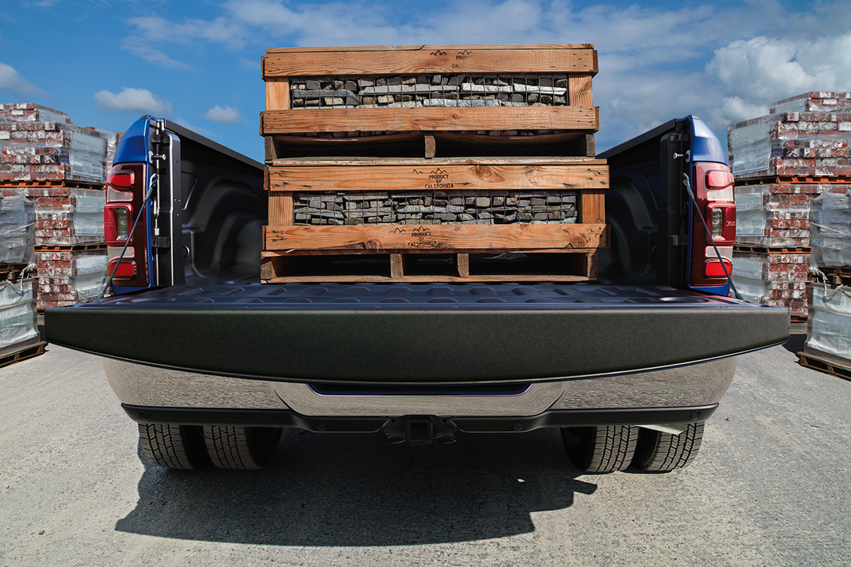 A rear view of a Patriot Blue 2021 Ram 3500 loaded with two pallets of two-by-fours in a lumber yard.