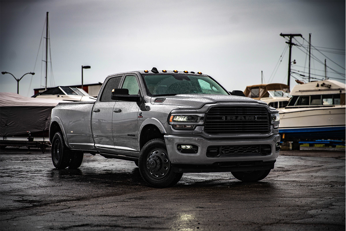 A Bright Silver Metallic coloured 2021 Ram 3500 parked in a marina with boats in the background.