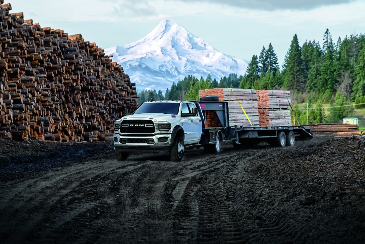 Un châssis-cabine Ram 5500 2019 tirant une remorque à deux essieux remplie de bois.