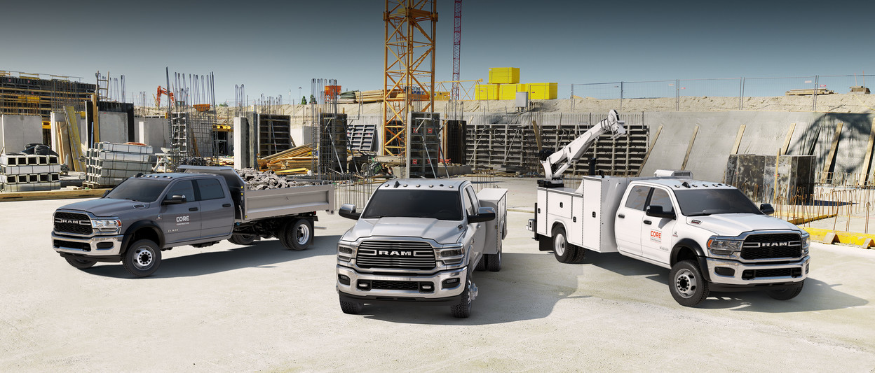 Three new 2019 Ram Chassis Cab vehicles parked in a large construction site.