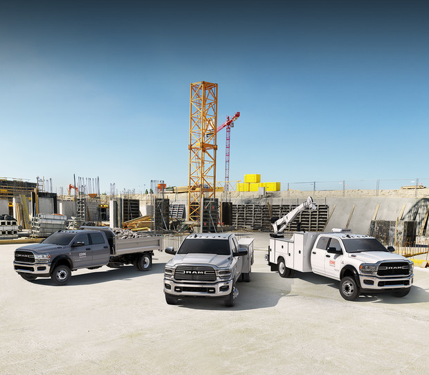 Three new 2019 Ram Chassis Cab vehicles parked in a large construction site.