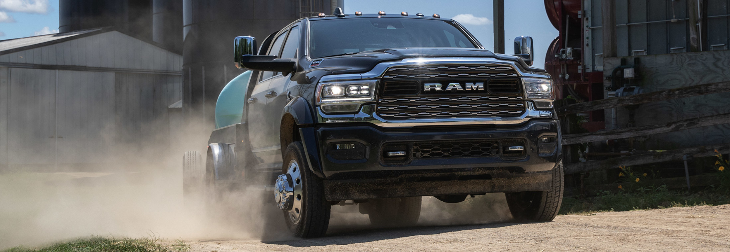 Front view of a black RAM Chassis Cab driving down a farm road