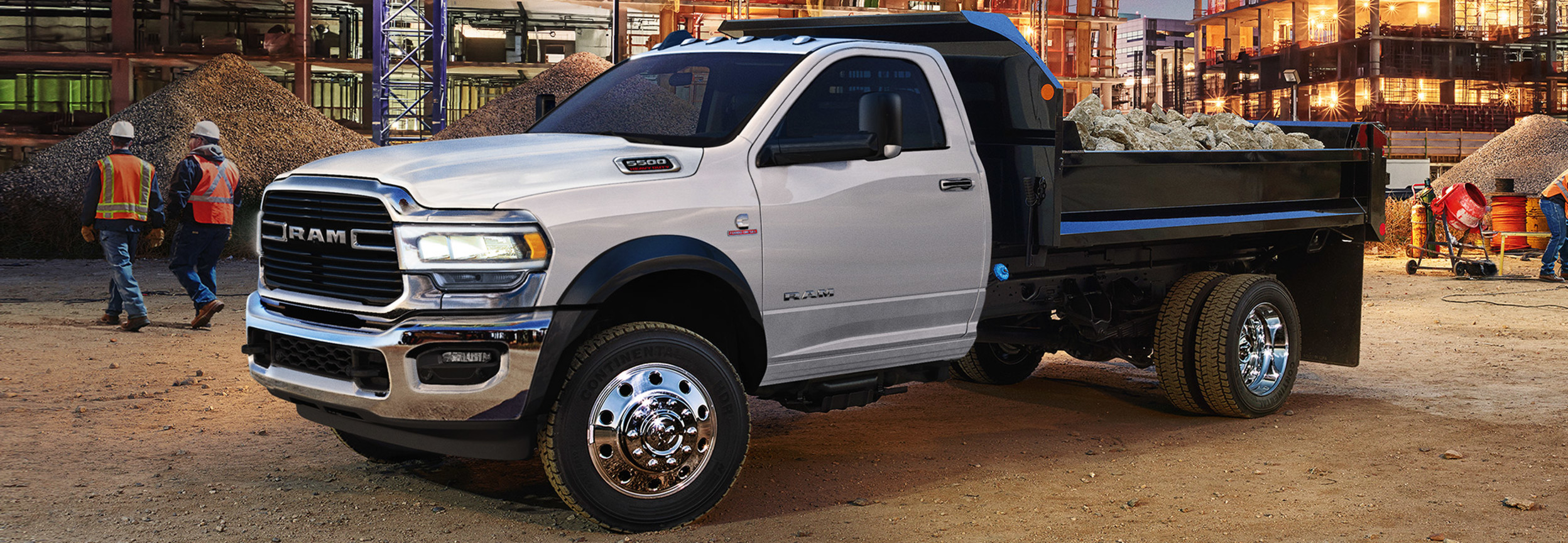 A white RAM Chassis Cab carrying construction material at a construction site