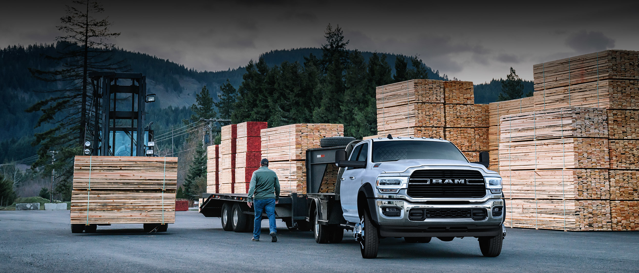 The white 2020 Ram Chassis Cab is parked in a loading zone while towing lumbers