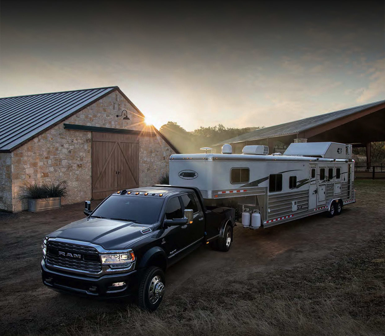 The black 2020 Ram Chassis Cab connected with camp trailer parked in front of barnyard