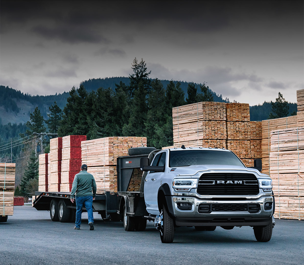 The white 2020 Ram Chassis Cab is parked in a loading zone while towing lumbers