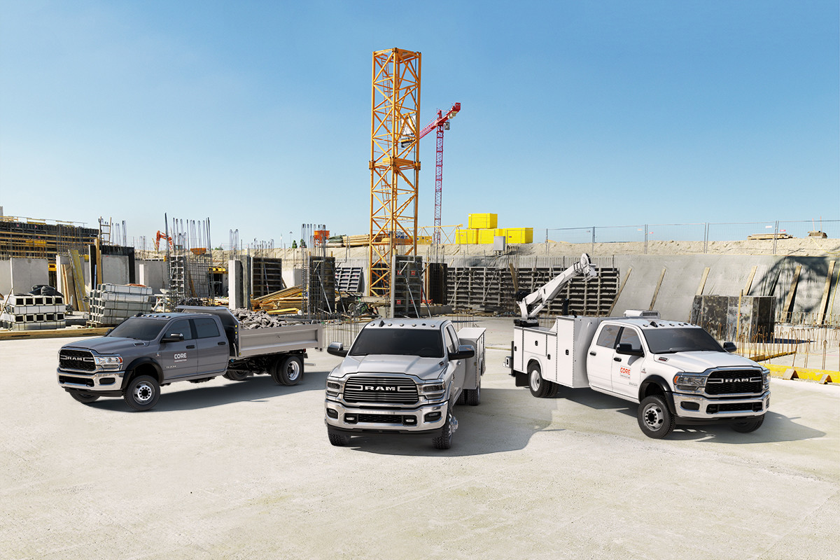 Un groupe de Ram châssis-cabines 2022 stationnés sur un site de construction avec divers équipements.