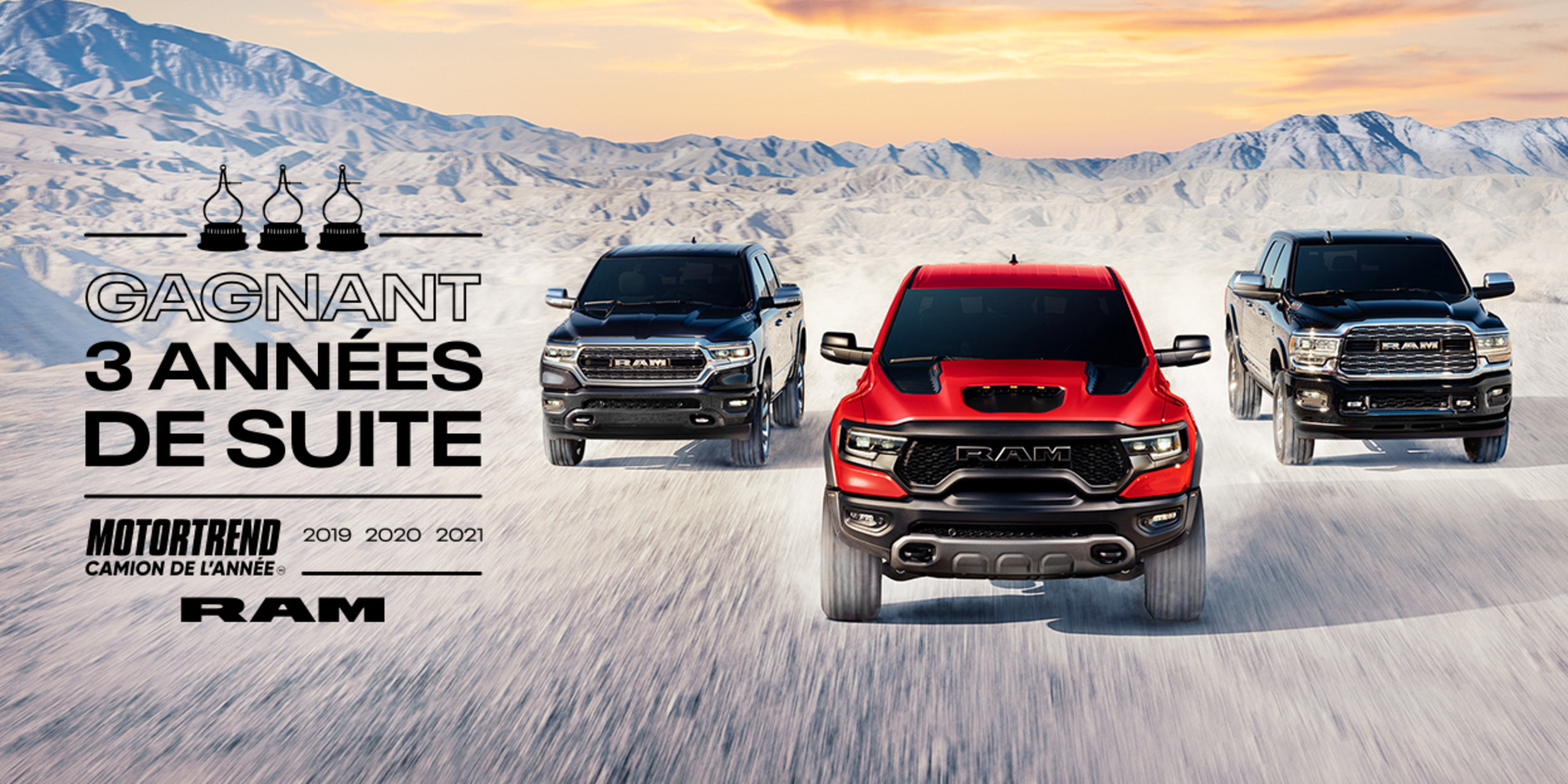 Gamme de camions RAM roulant dans la neige entourés d’une chaîne de montagnes. Trois fois au sommet du palmarès : le Ram a été déclaré Camion de l’année selon MotorTrend en 2019, 2020 et 2021.
