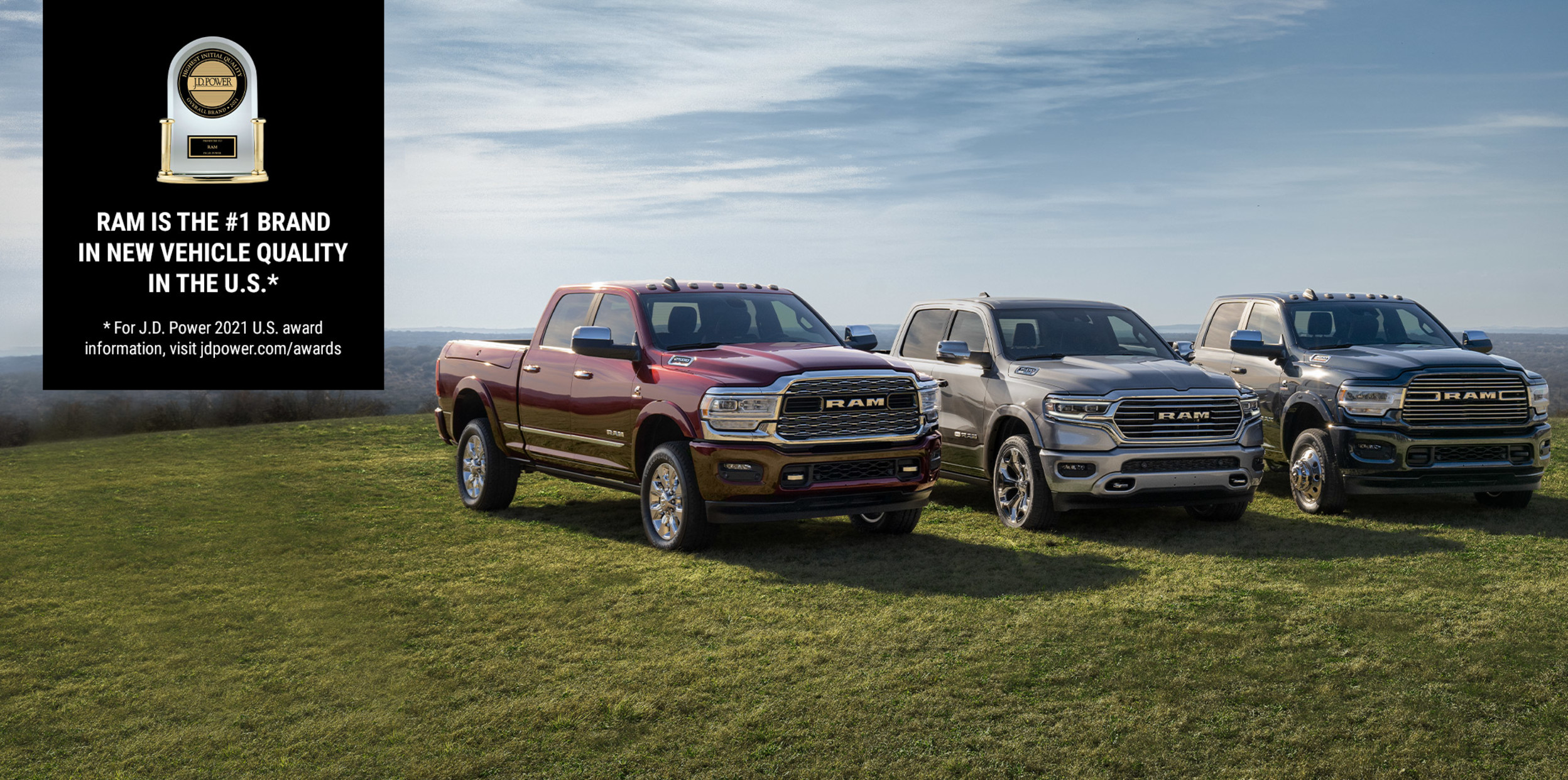 The Ram 1500, 2500 and 3500 pictured on a grassy plane with a J.D. Power award banner announcing “Ram is the #1 Brand in Initial Vehicle Quality in the U.S.”