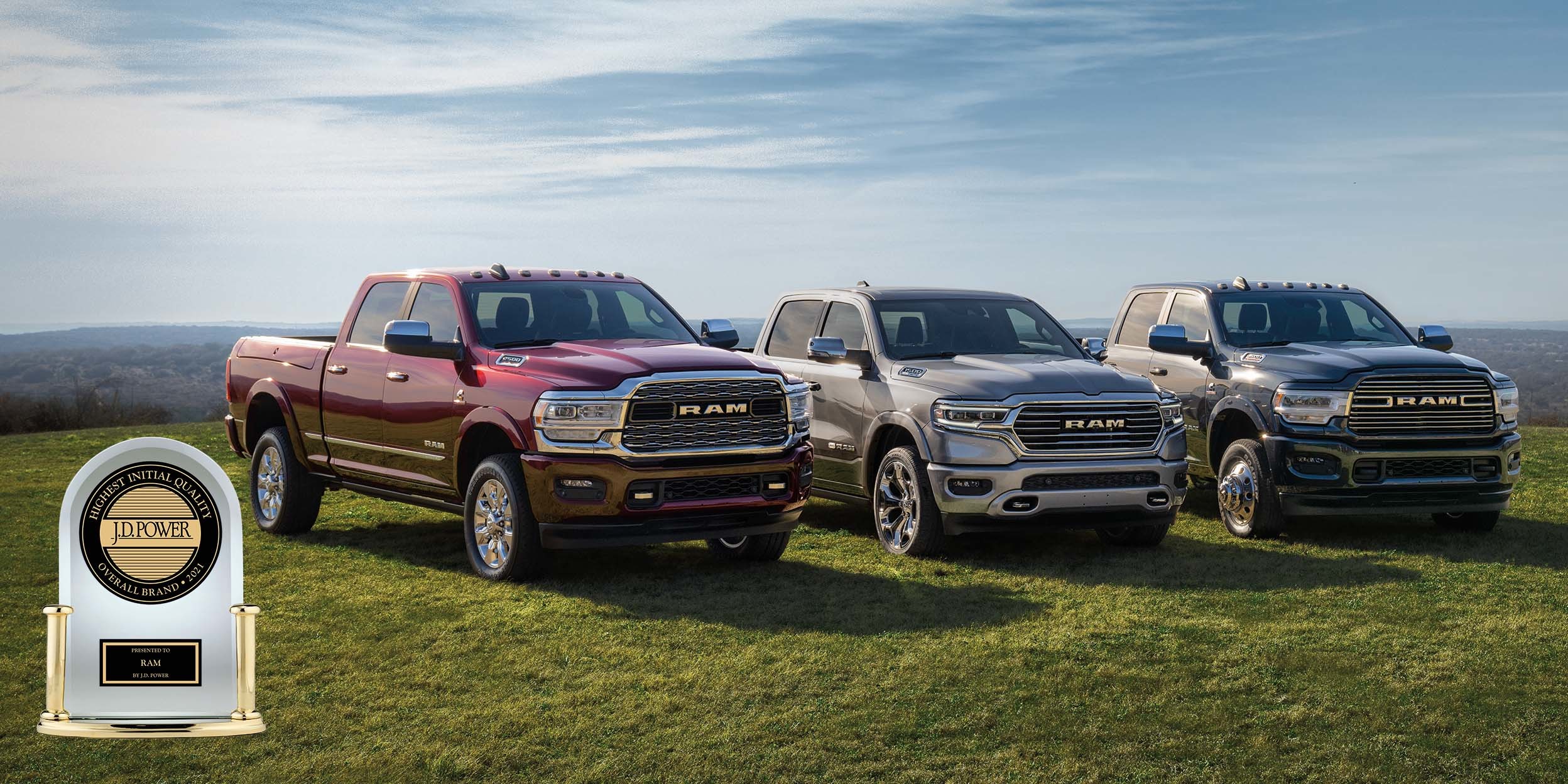 2500 Limited in Red Pearl and 3500 Limited in Brilliant Black Crystal Pearl and 1500 in silver parked on terrain with mountains in the distance.