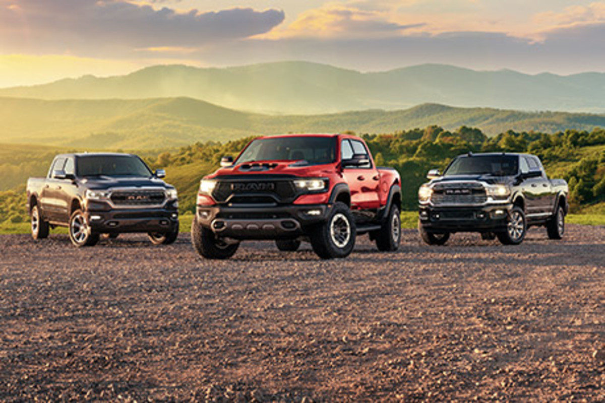 Les Ram 1500, Ram 1500 TRX et Ram 2500, tous garés dans un terrain vague avec des montagnes herbeuses en arrière-plan.