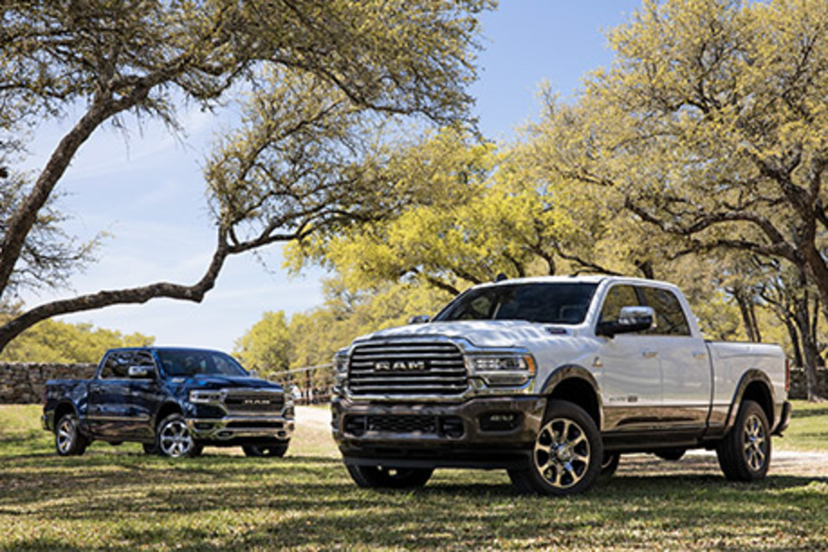 Un Ram 1500 Limited et un Ram 2500 Longhorn garés à l’extérieur près des arbres.